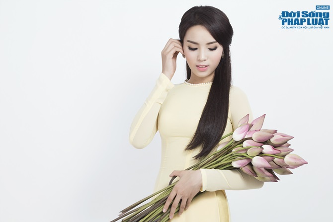Hoa hậu Nguyễn Cao Kỳ Duyên diện áo dài e ấp bên hoa sen