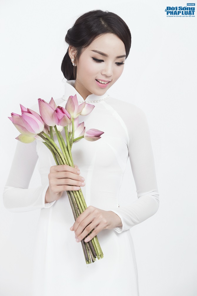 Hoa hậu Nguyễn Cao Kỳ Duyên diện áo dài e ấp bên hoa sen