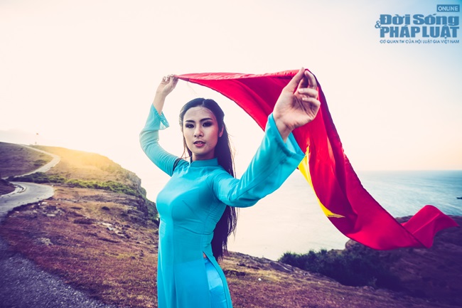 Ngọc Hân diện áo dài, cầm cờ Tổ Quốc tung bay trước biển