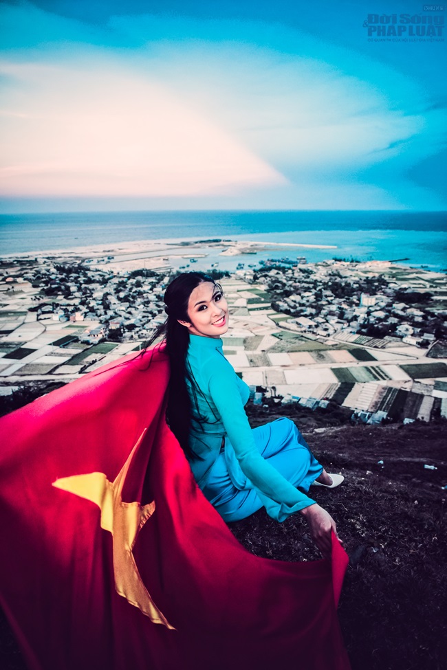 Ngọc Hân diện áo dài, cầm cờ Tổ Quốc tung bay trước biển