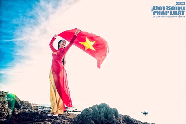 Ngọc Hân diện áo dài, cầm cờ Tổ Quốc tung bay trước biển