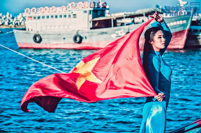 Ngọc Hân diện áo dài, cầm cờ Tổ Quốc tung bay trước biển