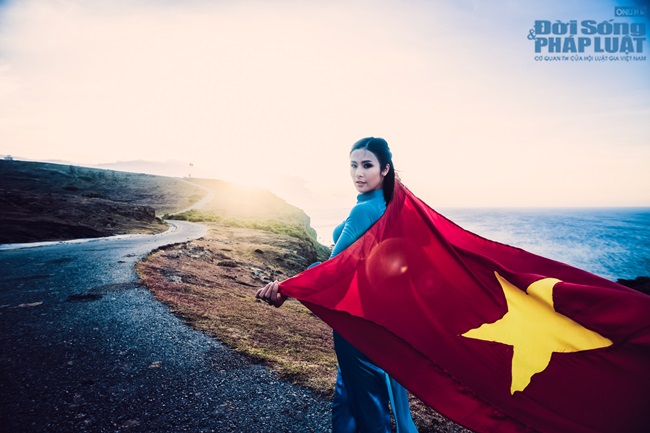 Ngọc Hân diện áo dài, cầm cờ Tổ Quốc tung bay trước biển