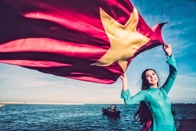 Ngọc Hân diện áo dài, cầm cờ Tổ Quốc tung bay trước biển