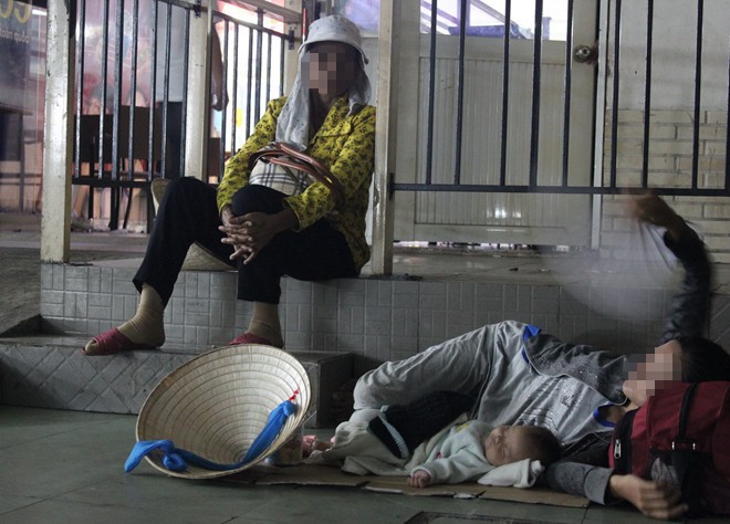 2 em bé ngủ dưới sàn nhà chờ bến xe Miền Đông