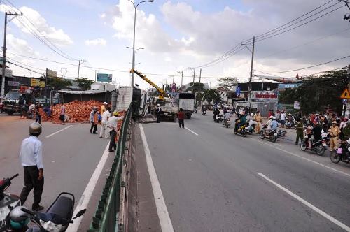 Xe tải chở gạch lật nhào suýt vùi lấp hai thanh niên