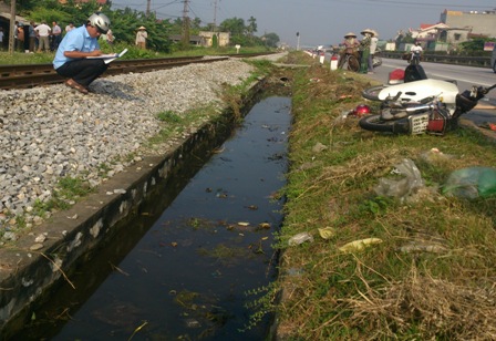 Một người dân đi xe máy từ đường dân sinh qua đường tàu sang Quốc