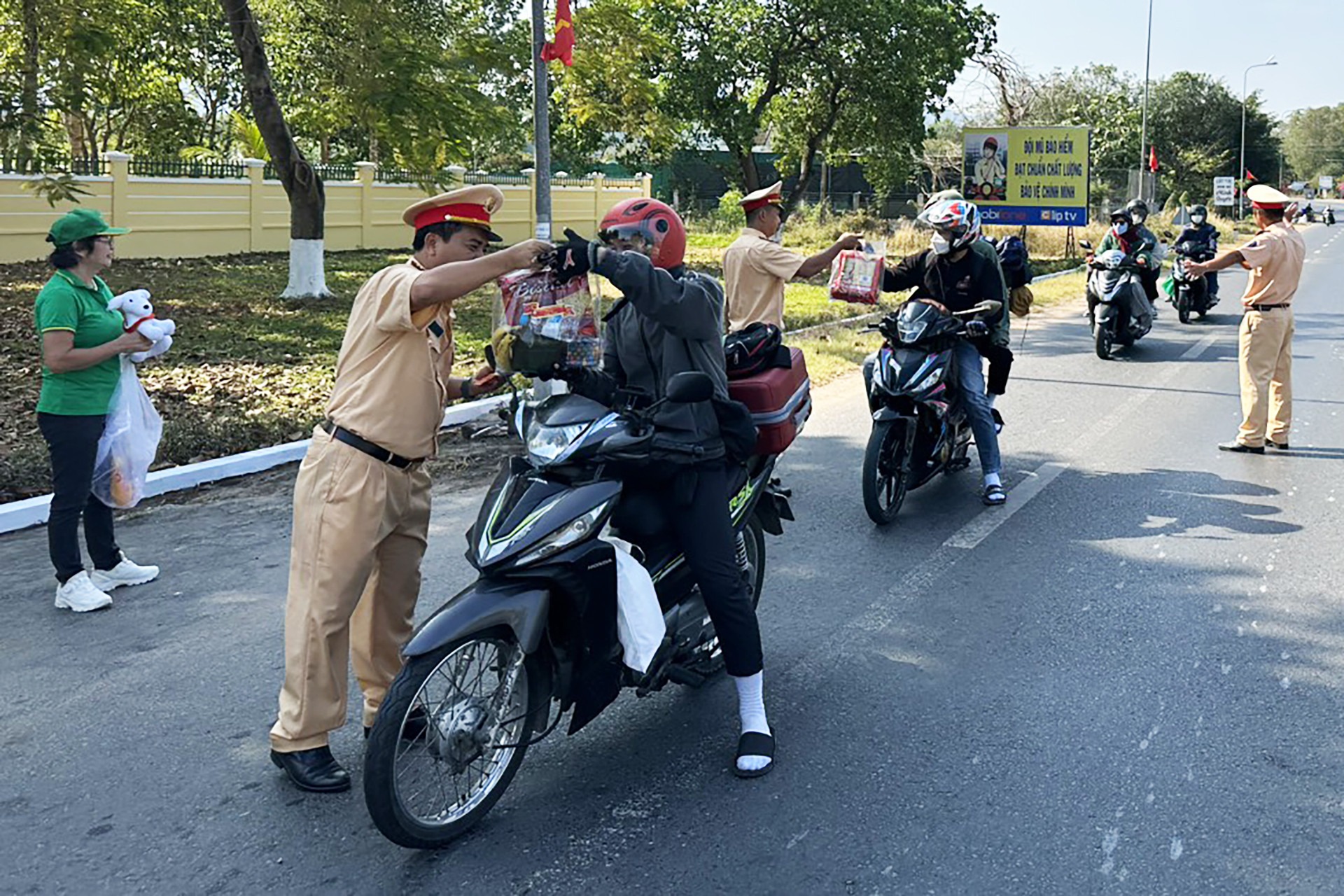 xuc dong hinh anh csgt tang mu bao hiem banh chung tiep suc cho nguoi dan ve que an tet 1