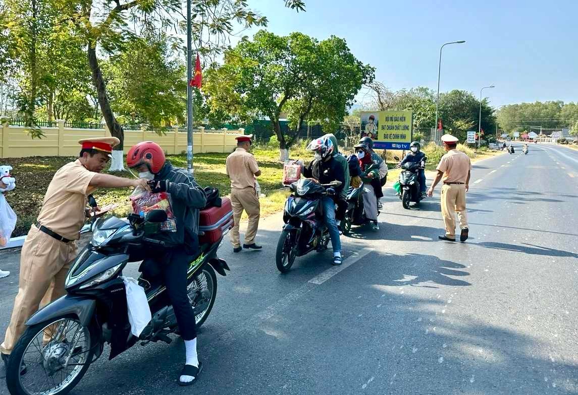 xuc dong hinh anh csgt tang mu bao hiem banh chung tiep suc cho nguoi dan ve que an tet 11