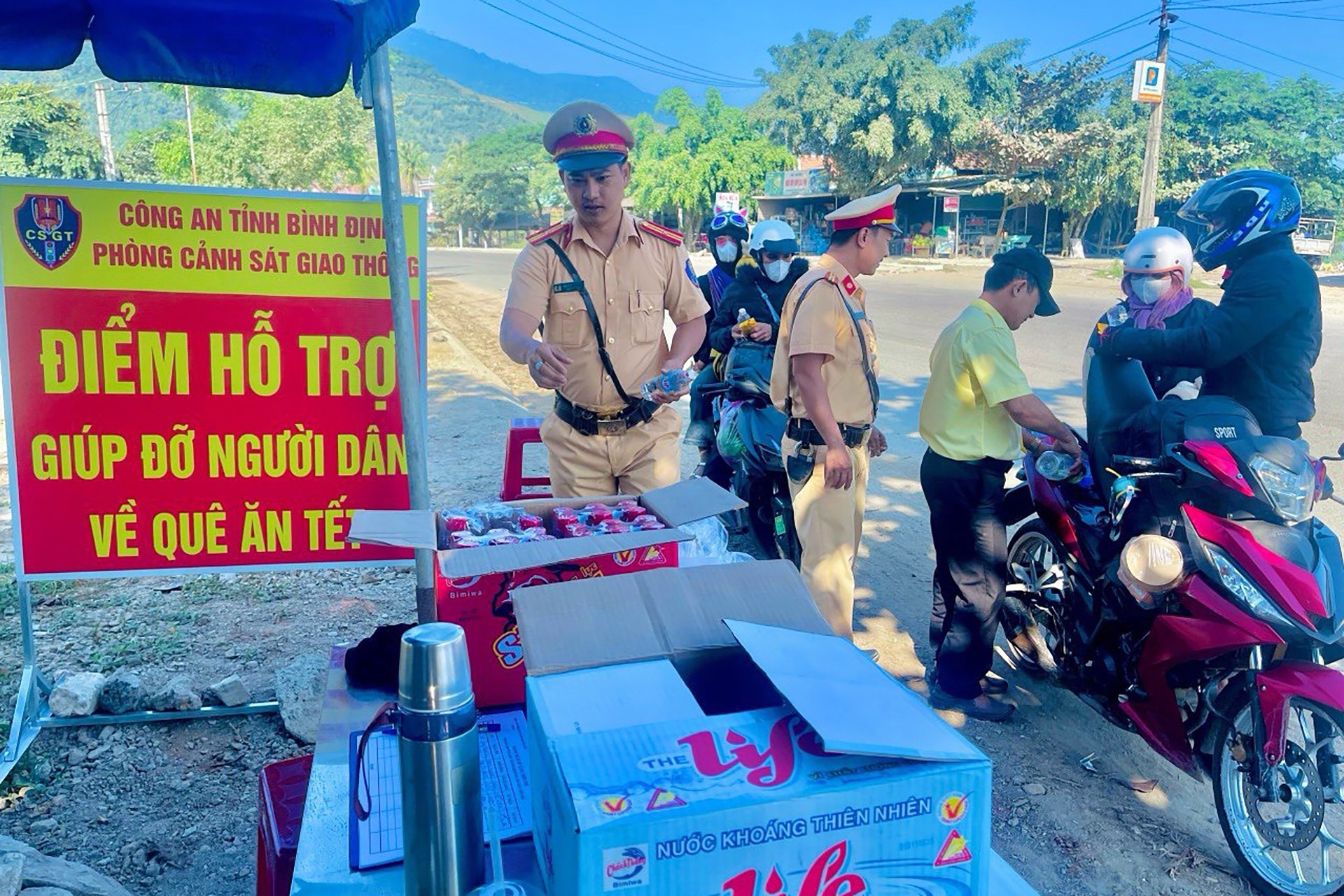 xuc dong hinh anh csgt tang mu bao hiem banh chung tiep suc cho nguoi dan ve que an tet 4
