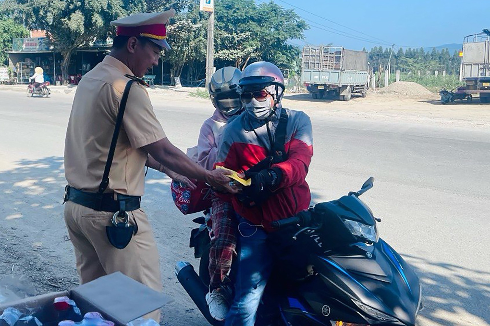 xuc dong hinh anh csgt tang mu bao hiem banh chung tiep suc cho nguoi dan ve que an tet 5