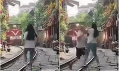 Hà Nội: Nữ du khách liều mình ra giữa đường ray tạo dáng khi tàu gần tiến đến
