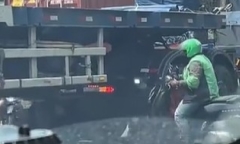 Clip: Bất chấp nguy hiểm, người đi xe máy chui gầm xe container để tránh tắc đường