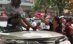 Nữ tài xế taxi mặc váy ngồi nóc ô tô chống đối CSGT