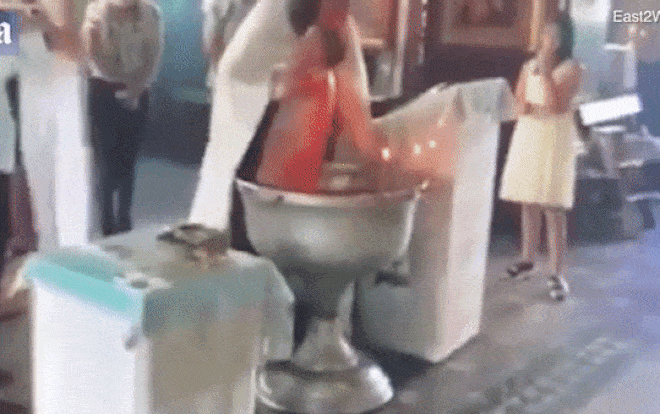 Hãi hùng cảnh linh mục làm lễ rửa tội cho trẻ như đánh vật