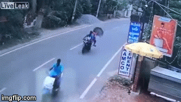 Video: Dùng ô khi đang ngồi xe máy, người phụ nữ ngã sấp mặt