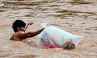 Video: Học sinh chui vào túi nilon vượt qua lũ dữ đến trường