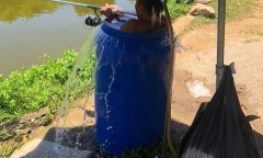 Thời tiết nắng nóng 40 độ, người đàn ông ngâm mình trong thùng phuy đầy nước để câu cá 