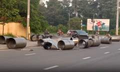 Xe đầu kéo ôm cua bị đứt xích, hơn chục cuộn tôn rơi xuống đường