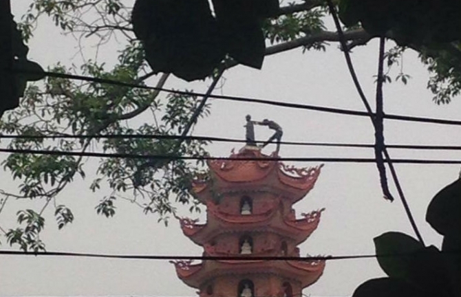 Thanh niên nghi ngáo đá trèo lên nóc tháp 11 tầng cố thủ