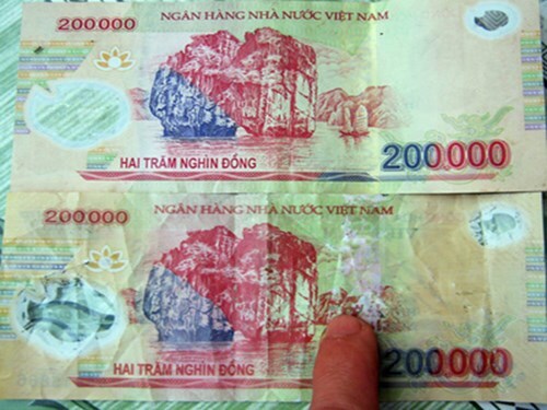 Bắt người đàn ông ôm hàng trăm tờ tiền giả đi mua vé số