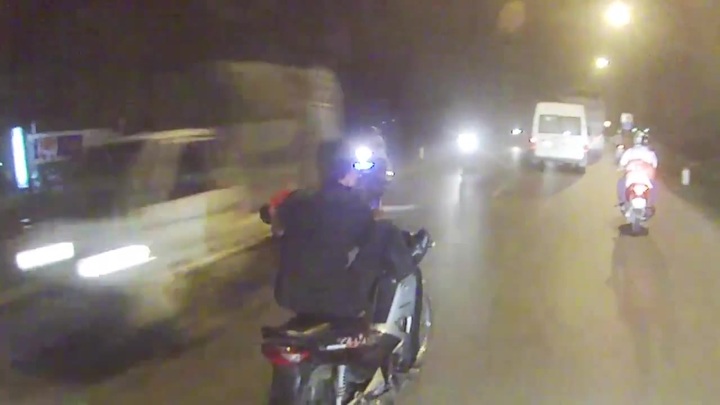 Nam thanh niên vừa đi xe máy bằng chân vừa vác đao