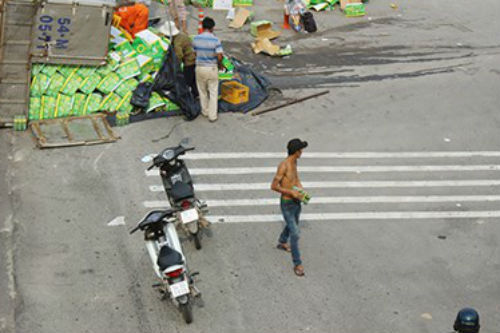 Xe tải chở nước ngọt lật nhào, nhiều người xông vào “hôi của”