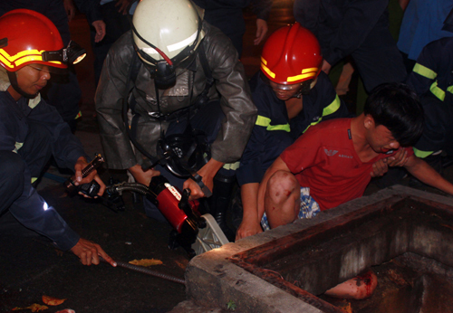 Lính cứu hỏa giải cứu thanh niên kẹt chân dưới cống thoát nước