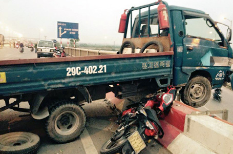 Gây tai nạn, chiếc xe tải nằm vắt vẻo giữa lan can trên cầu Thanh Trì