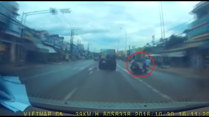 Tài xế xe máy ngã đột ngột trước đầu ôtô