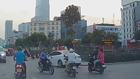 Hai bé gái ngồi trên nóc ô tô chạy khắp phố Hà Nội