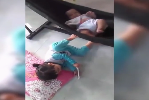 Khoảnh khắc bé gái đáng yêu đạp võng ru em ngủ khiến dân mạng thích thú