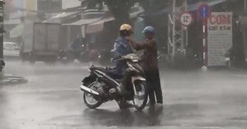 Khoảnh khắc xúc động: Bố dừng xe, chịu ướt mặc áo mưa cho con trai 30 tuổi