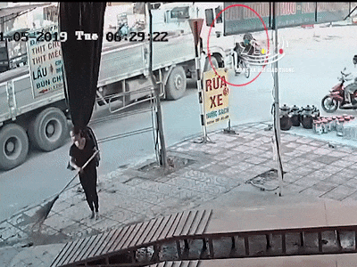 Vượt đầu xe tài đang vào khúc cua, người phụ nữ đi xe đạp suýt bị cán chết