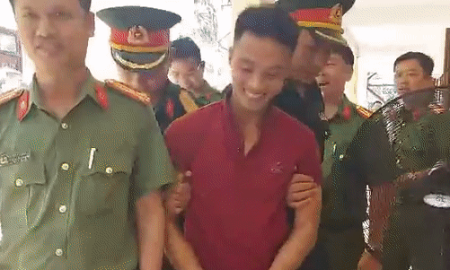 Triệu Quân Sự liên tục cười tươi khi bị còng tay, dẫn về trại giam