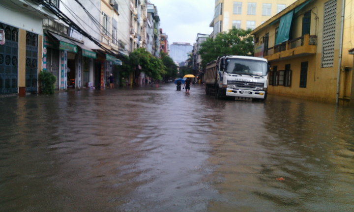 Chùm ảnh: Mưa lớn, dân Hà Nội bì bõm đi chợ trong biển nước