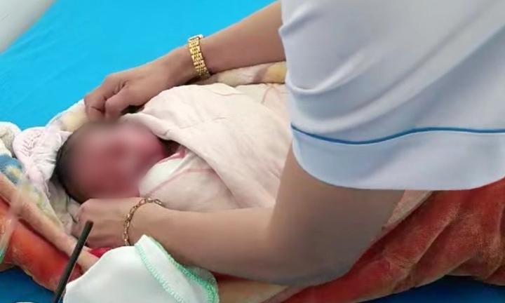 Bé trai sơ sinh được quấn áo khoác đỏ, còn nguyên dây rốn bị bỏ rơi