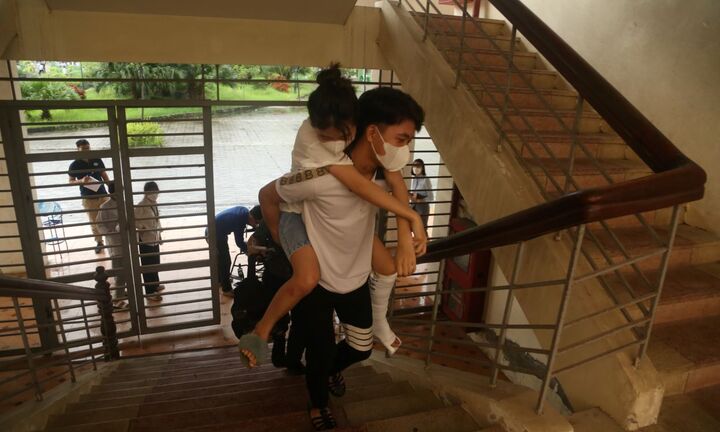 Người mẹ rơi nước mắt khi thấy con gái bị ngã gãy chân được cõng vào phòng thi