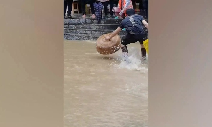 Người dân dùng lồng bàn bắt cá giữa đường