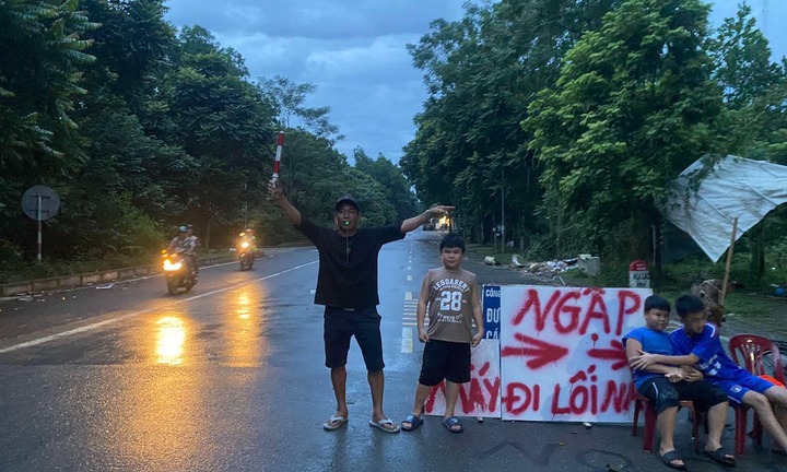 Danh tính bé trai ở Hà Nội gây sốt khi đứng chỉ đường cho xe cộ tránh đi vào nơi ngập lụt