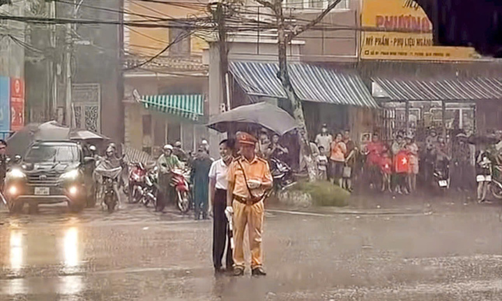 Clip: Cận cảnh người phụ nữ che ô cho CSGT dầm mưa làm nhiệm vụ