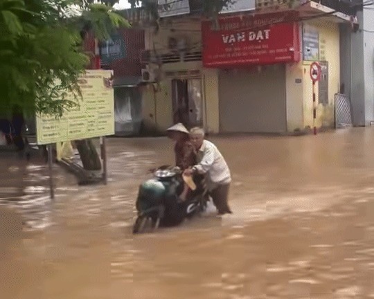 Rơi nước mắt khoảnh khắc ông lão Hà Nội đẩy xe giữa dòng nước ngập đưa vợ đi khám bệnh