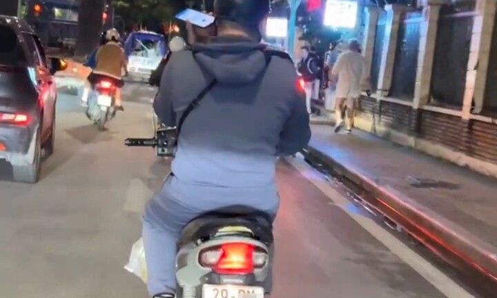 Nam thanh niên vừa lái xe máy vừa dùng điện thoại bị xử phạt 900.000 đồng
