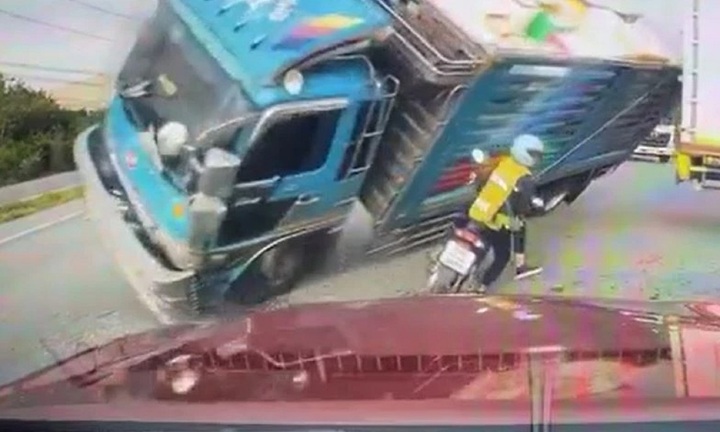 Clip: Xe tải mất lái lật nghiêng, đổ trúng người phụ nữ đi xe máy và cái kết bất ngờ
