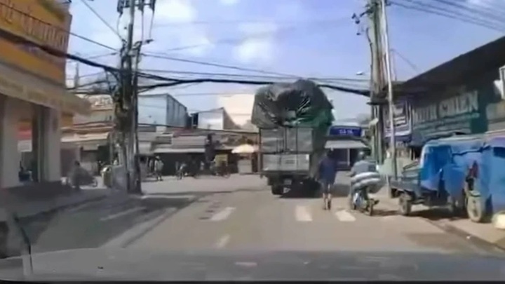 Clip hiện trường: Xe tải chở hàng vướng dây điện làm rơi bao hàng trúng người đi đường