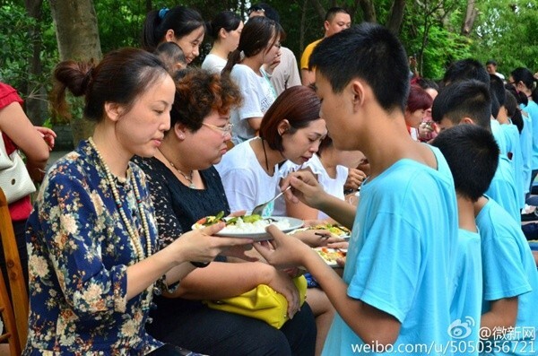 Bạn trẻ Trung Quốc quỳ gối bón cơm cho bố mẹ để bày tỏ lòng hiếu thảo