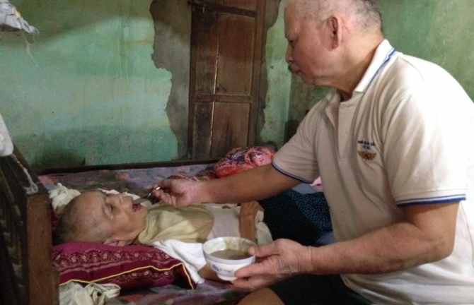 Cảm động chuyện người đàn ông suốt 16 năm bón cháo chăm vợ liệt giường