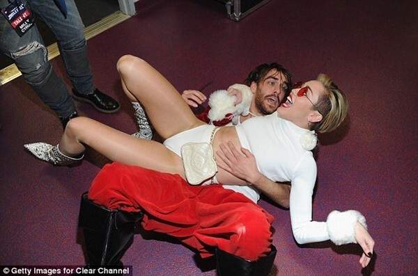 Miley Cyrus mặc nội y nằm đè lên người ông già Noel