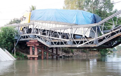 Xe chở 46 khối gỗ lơ lửng trên cầu sập