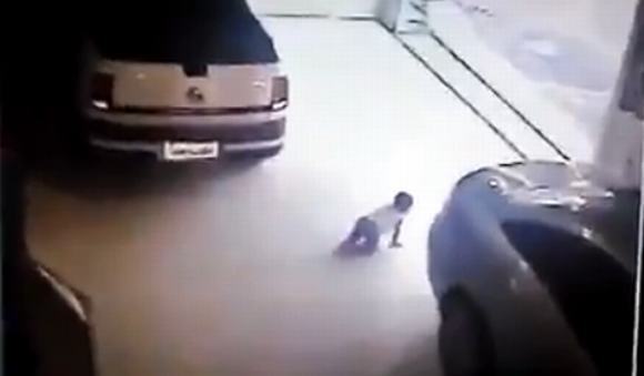 Clip: Kinh hoàng ôtô lùi chèn qua em bé đang bò